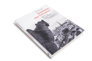 Eine Schrägansicht des Buches Städtebau des Erinnerns von Wolfgang Pehnt auf einem weißen Hintergrund. Das Cover zeigt eine Schwarz-Weiß-Fotografie von Paris mit dem Eiffelturm, gesehen von hinter einer steinernen Figur. Der Titel ist in Rot gedruckt, der Name des Autors und der Untertitel in Schwarz.