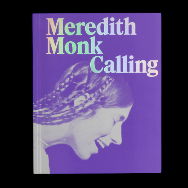 Das lila Cover des Buches Meredith Monk Calling. Der Titel ist in einer schillernden, holografischen Schriftart gedruckt. Darunter befindet sich ein monochromes Foto des lachenden Profils einer Frau mit geflochtenen Haaren.