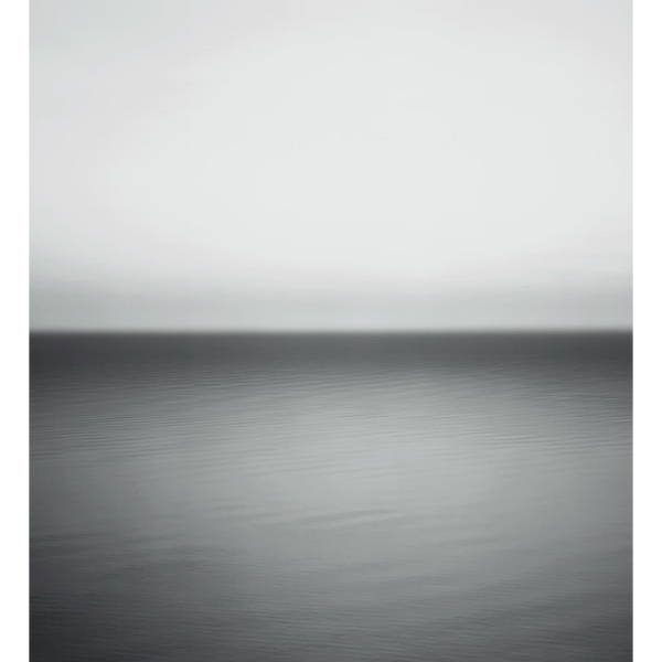 Eine minimalistische Schwarz-Weiß-Fotografie eines ruhigen Gewässers mit sanften Wellen, das am Horizont auf einen hellen Himmel trifft.