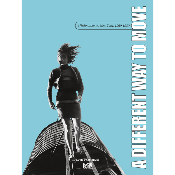 Das Buchcover zeigt eine Schwarz-Weiß-Fotografie einer Frau mit wehendem Haar, die auf einer großen, runden Struktur geht. Der Hintergrund ist hellblau und der Titel A DIFFERENT WAY TO MOVE steht vertikal am rechten Rand.
