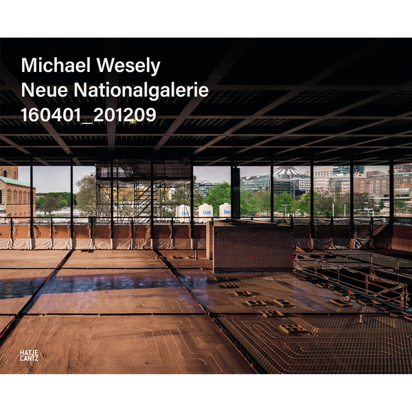 Eine Fotografie des Innenraums der Neuen Nationalgalerie während der Sanierung. Der Boden ist aufgerissen und durch die Fenster ist die Berliner Stadtlandschaft zu sehen.