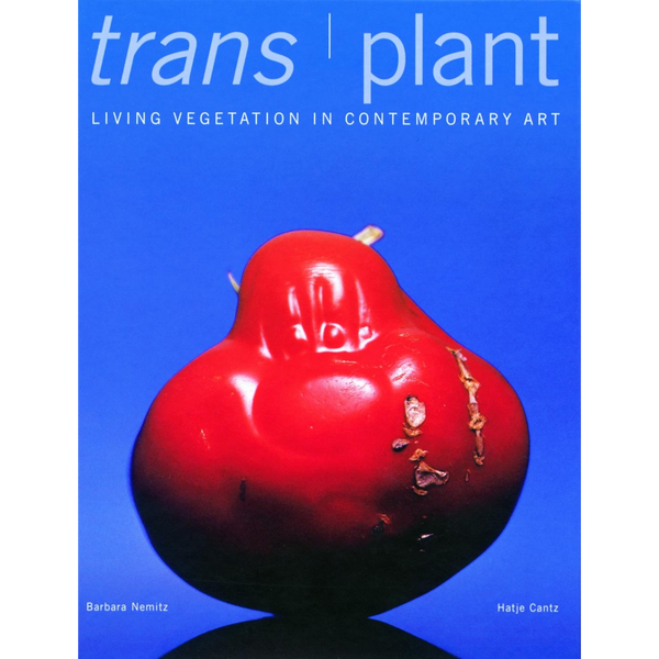 Das Buchcover von trans | plant zeigt eine große, rote, glänzende Frucht vor einem leuchtend blauen Hintergrund.