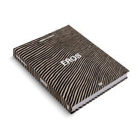 Ein Hardcover-Buch mit dem Titel EROS von Christl Mudrak, das schräg auf einem weißen Hintergrund liegt. Der Einband hat ein auffälliges Muster aus wellenförmigen schwarzen und beigen Streifen, wobei der Titel und der Name der Autorin in Weiß aufgedruckt sind.