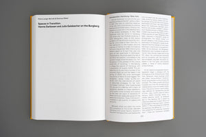 Ein aufgeschlagenes Buch mit gelbem Einband liegt auf einer grauen Oberfläche. Auf der linken Seite steht der Titel Spaces in Transition, auf der rechten Seite beginnt ein zweispaltiger Text mit der Überschrift Introduction: Hamburg / New York.