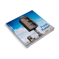 Ein quadratisches Buch mit dem Titel The Best of Frank Kunert auf einem weißen Hintergrund. Das Coverbild ist ein surreales Foto eines Hotels in Form einer riesigen Beton-Parkuhr, das in einer Dünenlandschaft steht.