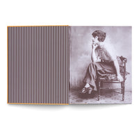 Ein aufgeschlagenes Buch, links eine Seite mit vertikalen, weiß-braunen Streifen, rechts eine Schwarz-Weiß-Fotografie einer Frau, die in nachdenklicher Pose auf einem Stuhl sitzt.